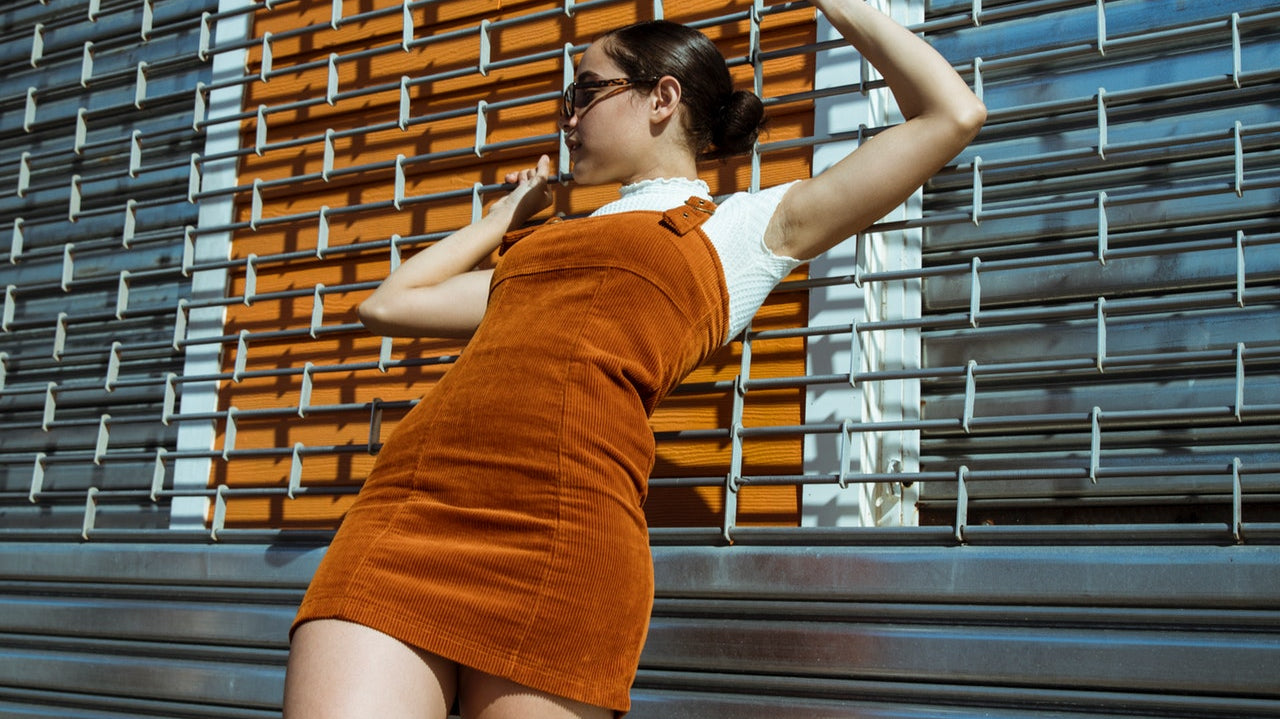 Young woman in rust colored tank style corduroy dress