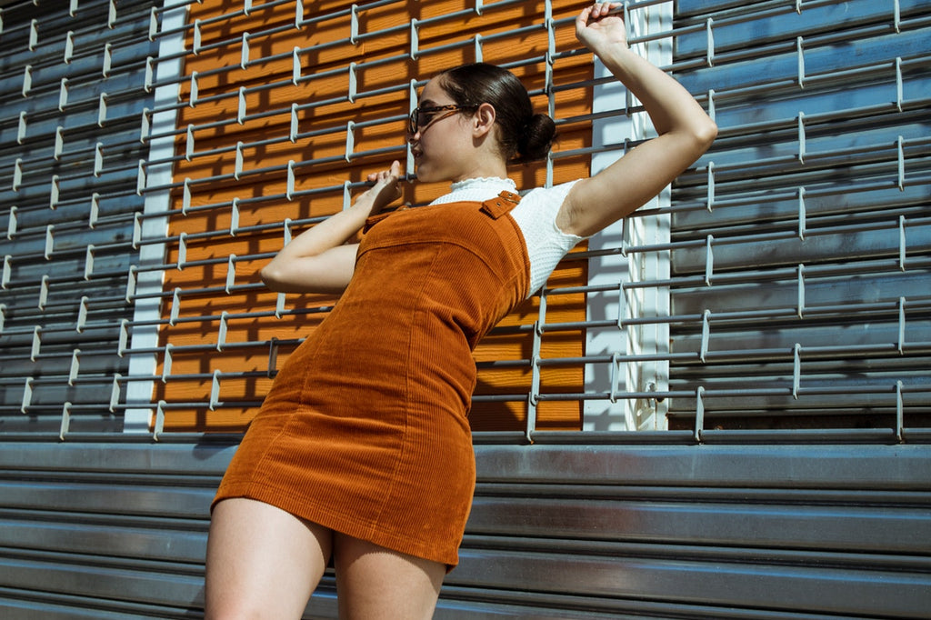 Young woman in rust colored tank style corduroy dress